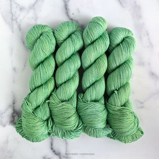Green yarn skeins on a marble background